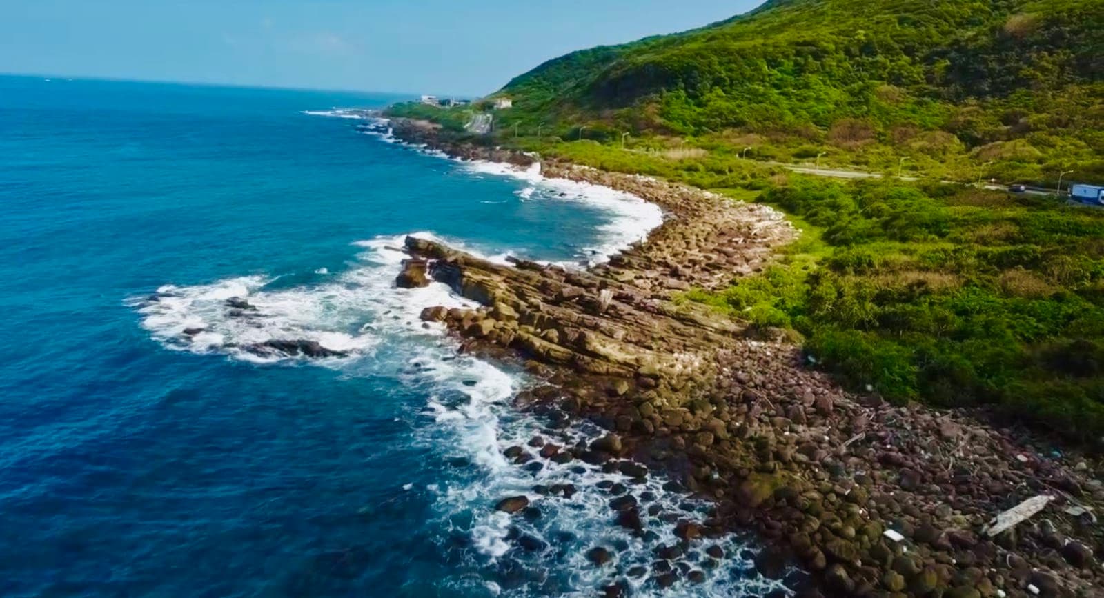 東北角岩岸與浪花航拍,翠綠山丘與蔚藍海面